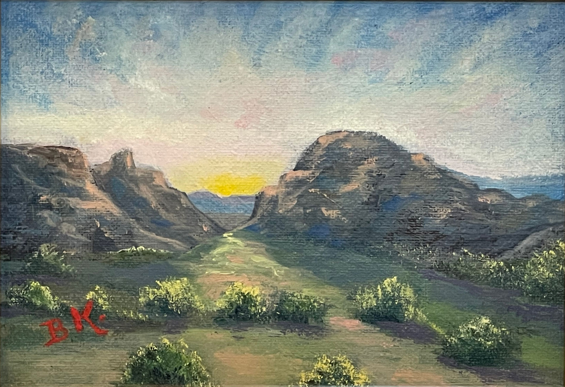 Oil Painting of a sun setting between two mountains in the Big Bend National Park. Painted by B.K. Dennis of Alpine, TX.
